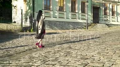 穿着时髦<strong>鞋子</strong>穿着粉色<strong>包包</strong>的迷人女人在城市的石路上散步